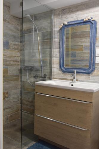 une salle de bain avec un lavabo et une douche en verre dans l'établissement Logement spacieux au calme - Plage des Chalets, à Gruissan