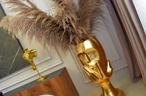 a gold statue with feathers on top of a table at Boka Devine Residence in Kotor