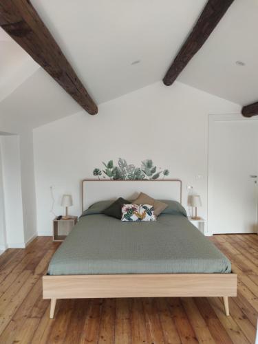 a bed in a room with white walls and wooden floors at Casa Ilanga in Cannero Riviera