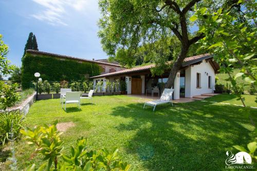 un patio con 2 sillas y una casa en Il Podere del Bardo, en Puegnago sul Garda