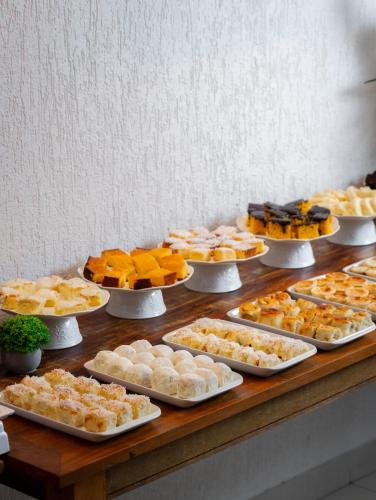 a table with many different types of food on plates at Hotel Bons Tempos in Rio Verde