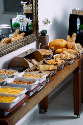 a table topped with lots of different types of bread at Hotel Bons Tempos in Rio Verde