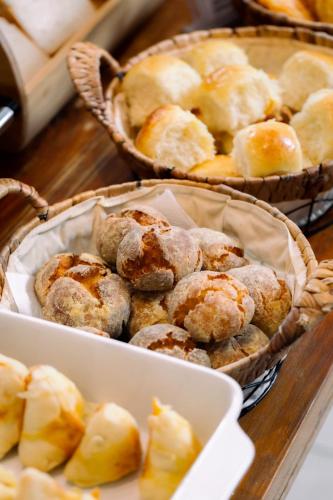 a table with two baskets of pastries and a plate of bread at Hotel Bons Tempos in Rio Verde