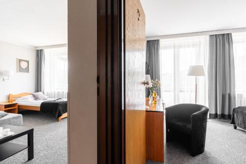 a living room with a couch and a chair in a room at Hotel Helios 300m od Krupówek nowy BASEN od 12 lipca in Zakopane
