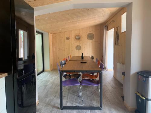 Un comedor con mesa y sillas de madera. en La Petite Auberge Insolite, en Saint-Affrique
