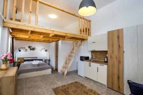 a bedroom with a loft bed and a kitchen at Marti Garden Suites in Skala Prinou