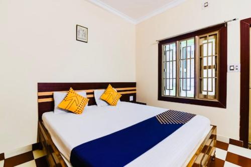 a bedroom with a large bed with yellow and blue pillows at Hotel Golden Dust ! Puri - ViDi Group of Hotels in Puri