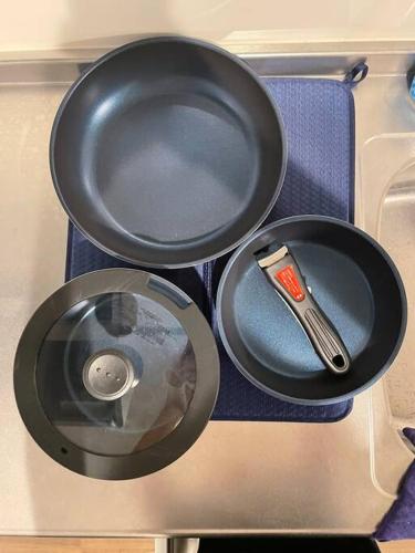 two pans sitting on a stove with a utensil at 箱根湯本から一駅。大正〜昭和の家具に囲まれた、緑香るウッドテラスのある宿。高台から小田原の街を一望　 in Odawara