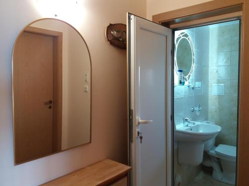 a bathroom with a sink and a toilet and a mirror at Апартамент в комплекс Зора 9A in Sozopol