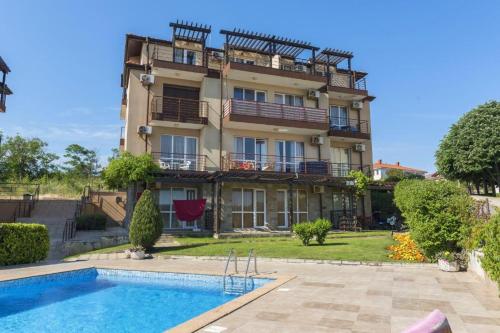 a building with a swimming pool in front of a building at Апартамент в комплекс Зора 9A in Sozopol