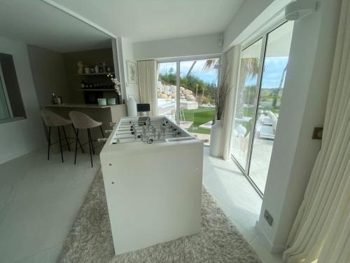 a white kitchen with a stove top oven in a room at Villa design vue panoramique in Grabels