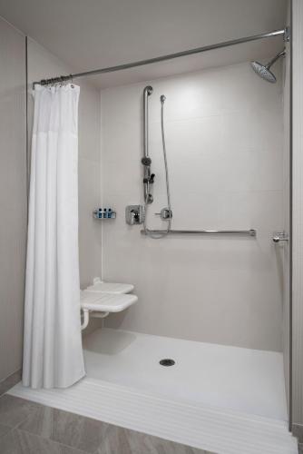 a white bathroom with a shower and a sink at Delta Hotels by Marriott Richmond Downtown in Richmond
