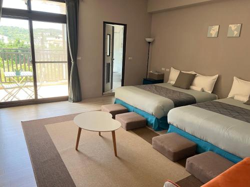 ein Hotelzimmer mit 2 Betten und einem Tisch in der Unterkunft el Bulli Inn in Hualien