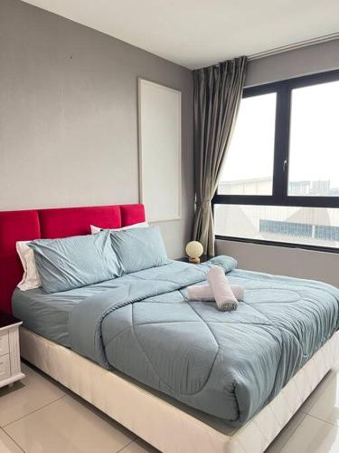 Schlafzimmer mit einem großen Bett mit einem roten Kopfteil in der Unterkunft Shah Alam @ Hyde Tower I-City in Shah Alam