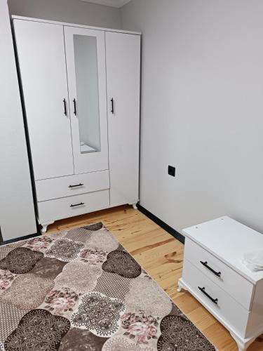 a bedroom with a bed and a dresser and a rug at Erdoğan Konut in Çaykara