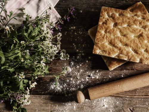 a close up of a piece of pie on a wooden table with flowers at Villa di Piazzano - Small Luxury Hotels of the World in Cortona