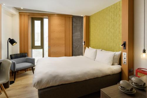 a hotel room with a large bed and a chair at Market Street hotel in Edinburgh