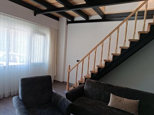 a living room with a couch and a staircase at Erdoğan Konut in Çaykara