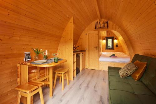 pokój ze stołem i łóżkiem w kabinie w obiekcie Kampinastaete, hippe cottages midden in natuurgebied de Kampina Oisterwijk w mieście Oisterwijk
