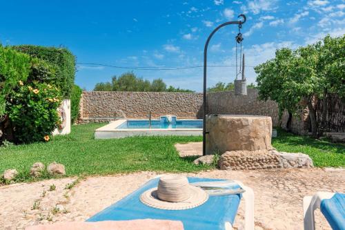 een hoed op een tafel naast een zwembad bij Villa Can Guaita II in El Port