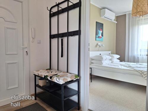 a small bedroom with a bed and a mirror at Kavics Apartman Tata in Tata