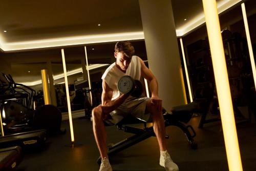 a man sitting on a chair holding a frisbee at Sofitel Barcelona Skipper in Barcelona