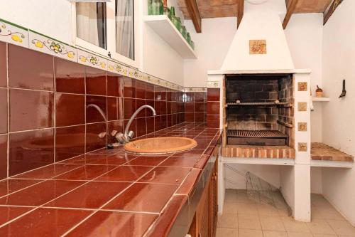 a kitchen with a counter with a sink and an oven at Villa Can Guaita II in El Port