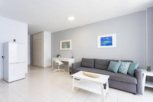 salon z kanapą i stołem w obiekcie Bonito apto Los Cristianos, vistas al mar y playa w mieście Los Cristianos