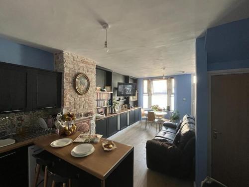 a kitchen and living room with a couch and a table at Charming newly renovated terrace in Liverpool