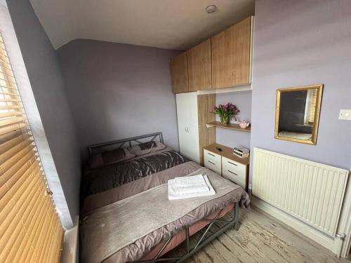 a small bedroom with a bed and a tv at Charming newly renovated terrace in Liverpool