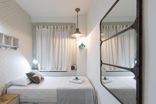 a bedroom with two beds and a mirror at Astoria - baskeyrentals in San Sebastián