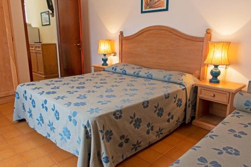 1 dormitorio con 2 camas y 2 lámparas en Elbamar Procchio, en Procchio