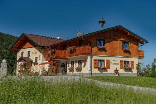 a large house with a wooden roof at Apparthaus Taxegger in Haus im Ennstal
