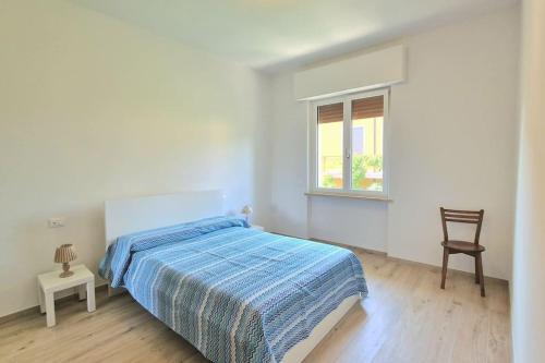 a bedroom with a bed and a chair and a window at S.Benedetto Terrace apartment in Peschiera del Garda