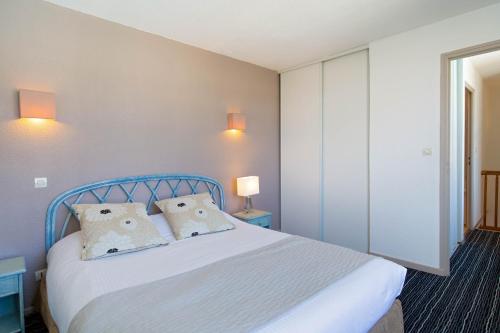 - une chambre avec un lit bleu et 2 oreillers dans l'établissement Duplex à La Marina, à Saint-Raphaël