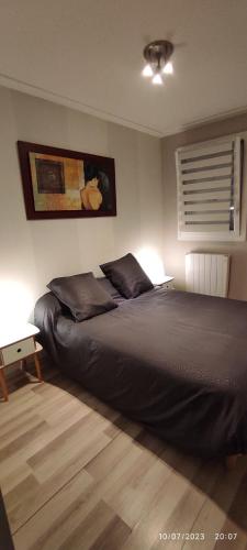 - une chambre avec un lit et une table éclairée dans l'établissement Le VIP cabourg,200m de la plage et de la promenade Marcel Proust,600m du centre, agréable F2 en rez de jardin, à Cabourg