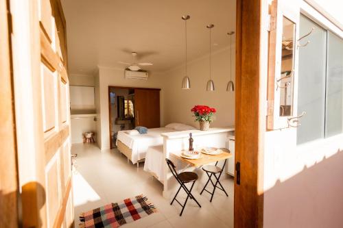 Zimmer mit einem Bett, einem Tisch und einem Bett in der Unterkunft Suites em Jabaquara, Paraty in Paraty