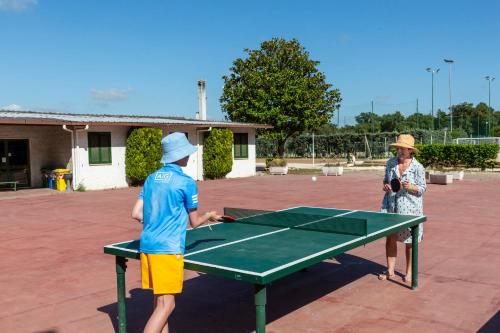 two people playing ping pong on a ping pong table at Fabulous village in Casal Palocco