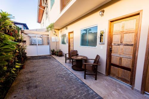 a corridor of a house with a table and chairs at Suites em Jabaquara, Paraty in Paraty