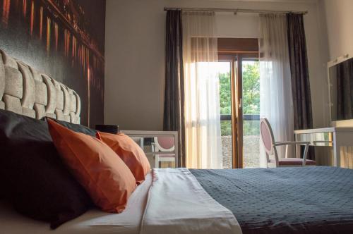 een slaapkamer met een bed met kussens en een raam bij Bright Side Apartment in Novi Sad