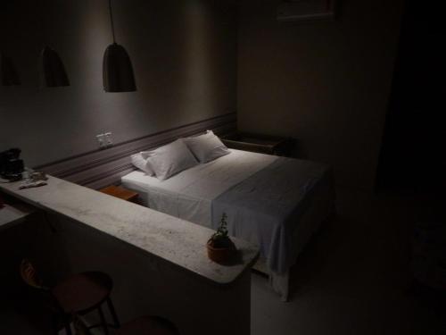 a small bedroom with a bed and a table at Suites em Jabaquara, Paraty in Paraty