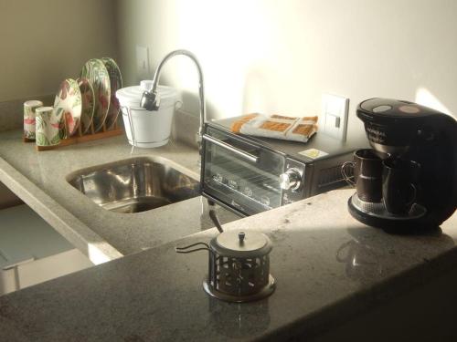 a kitchen counter with a mixer and a sink at Suites em Jabaquara, Paraty in Paraty