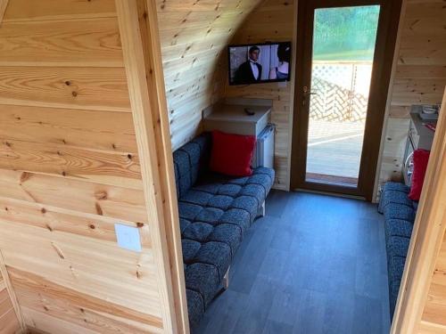 a living room with a couch in a wooden cabin at seven acre farm campsite in Fiskerton