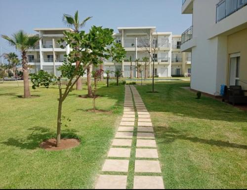 a walkway in a park next to a building at Casabay appartement 87 m2 très proche de la plage in Sidi Rahal