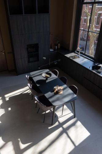 a table and chairs in a kitchen with a sink at Park Lofts Groningen apartment 3 in Groningen