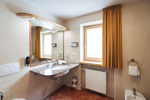 a bathroom with a sink and a mirror at Hotel Bambi Am Park in Solda