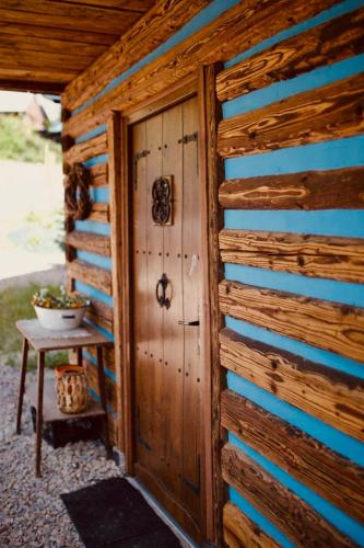 einem Holzschuppen mit einer Tür und einem Tisch in der Unterkunft Ranczo nad Cedronem in Kalwaria Zebrzydowska