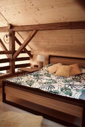 a bedroom with a bed in a wooden room at Ranczo nad Cedronem in Kalwaria Zebrzydowska