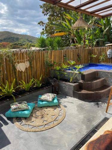 a backyard with a swimming pool and a wooden fence at Loft Mandalua in Serra do Cipo