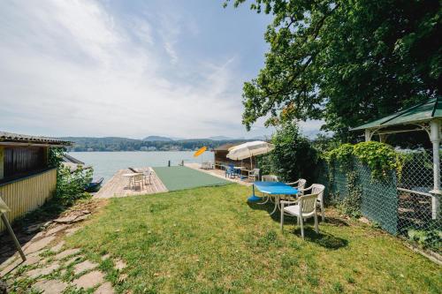a backyard with a table and chairs and a dock at Gästehaus Frank in Velden am Wörthersee